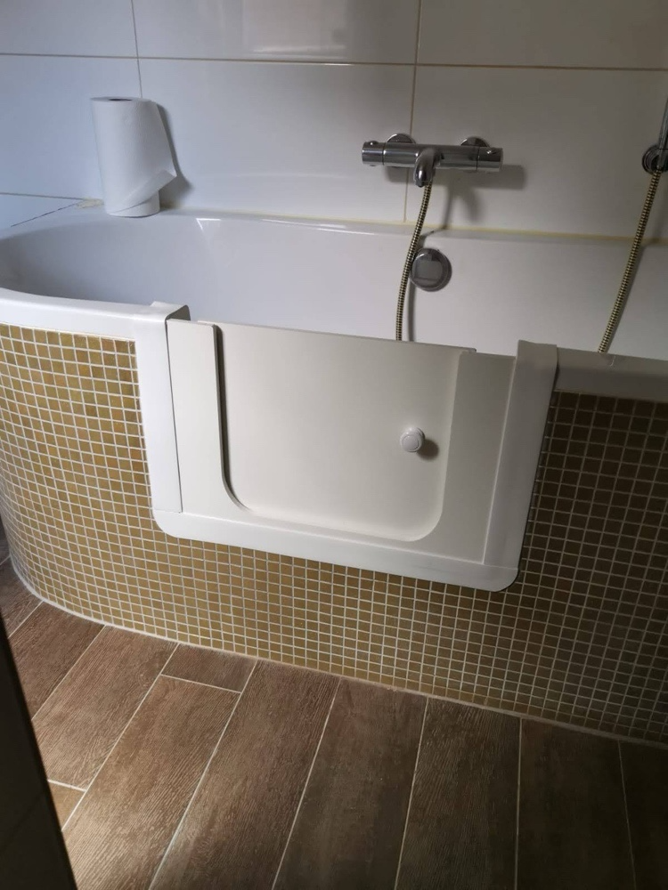 Baddeur met geopende instapdeur in een bestaand ligbad