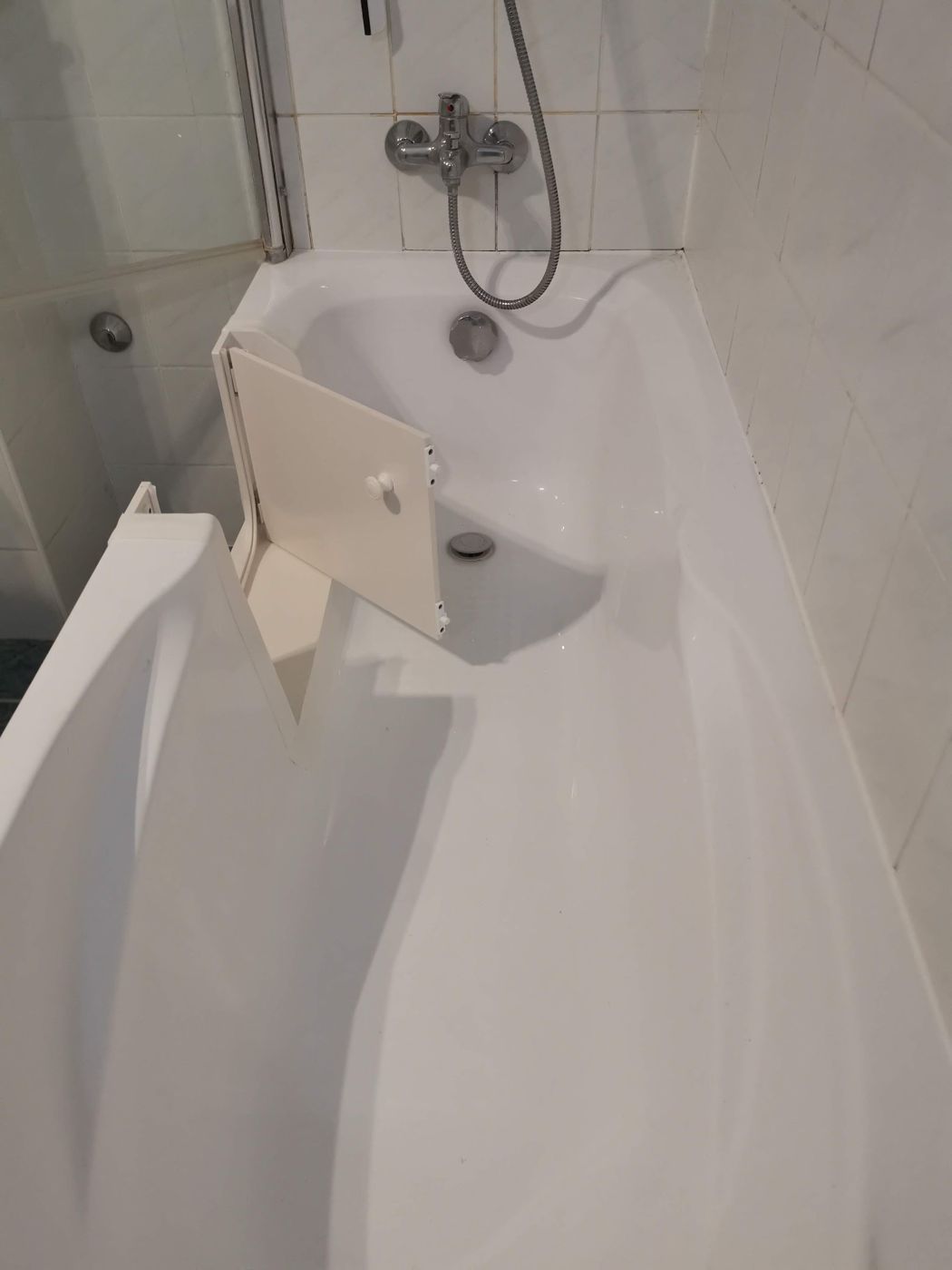 Baddeur in een hoekbad in een witte badkamer