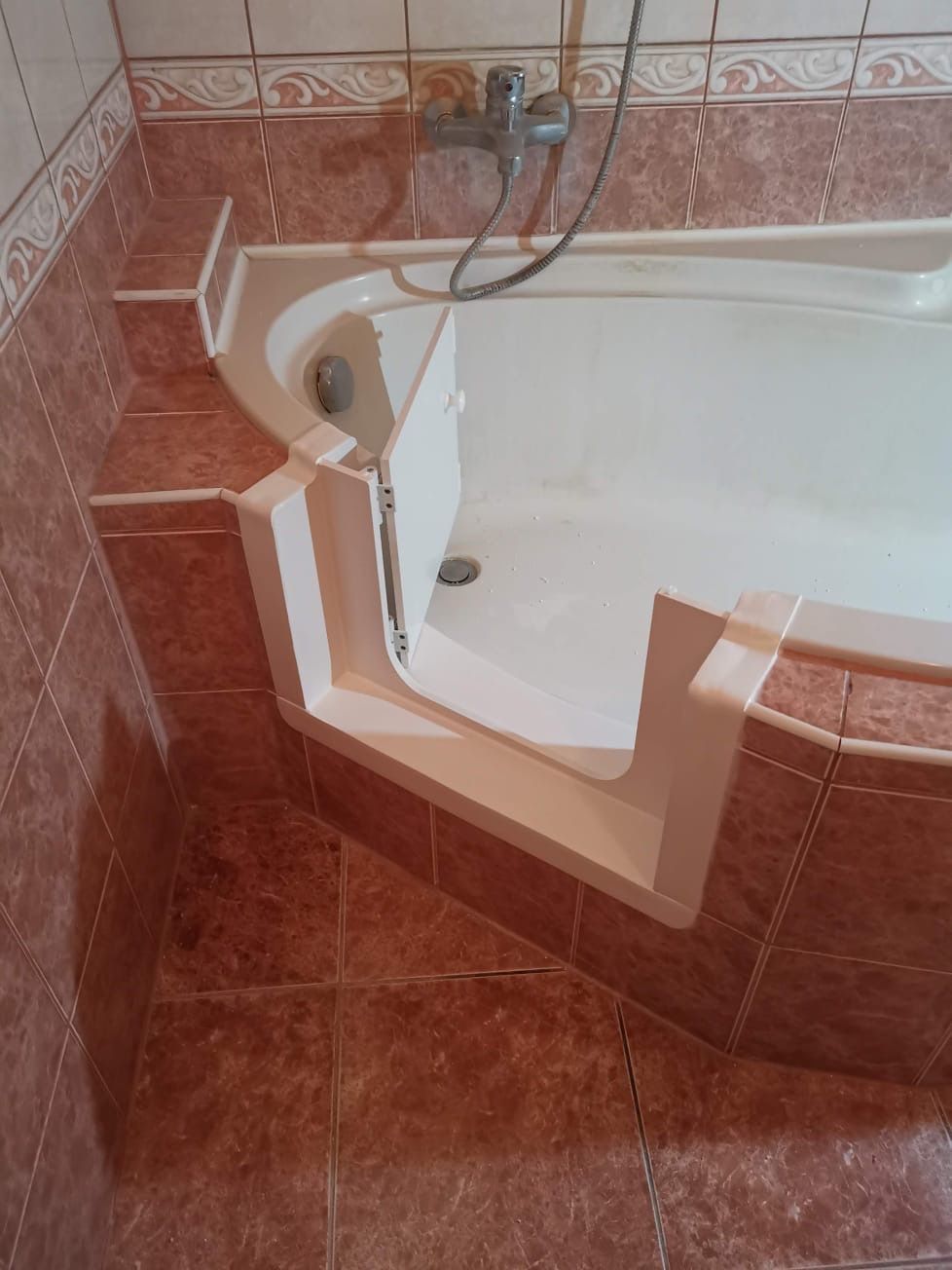 Baddeur in een bad met rode tegelvloer