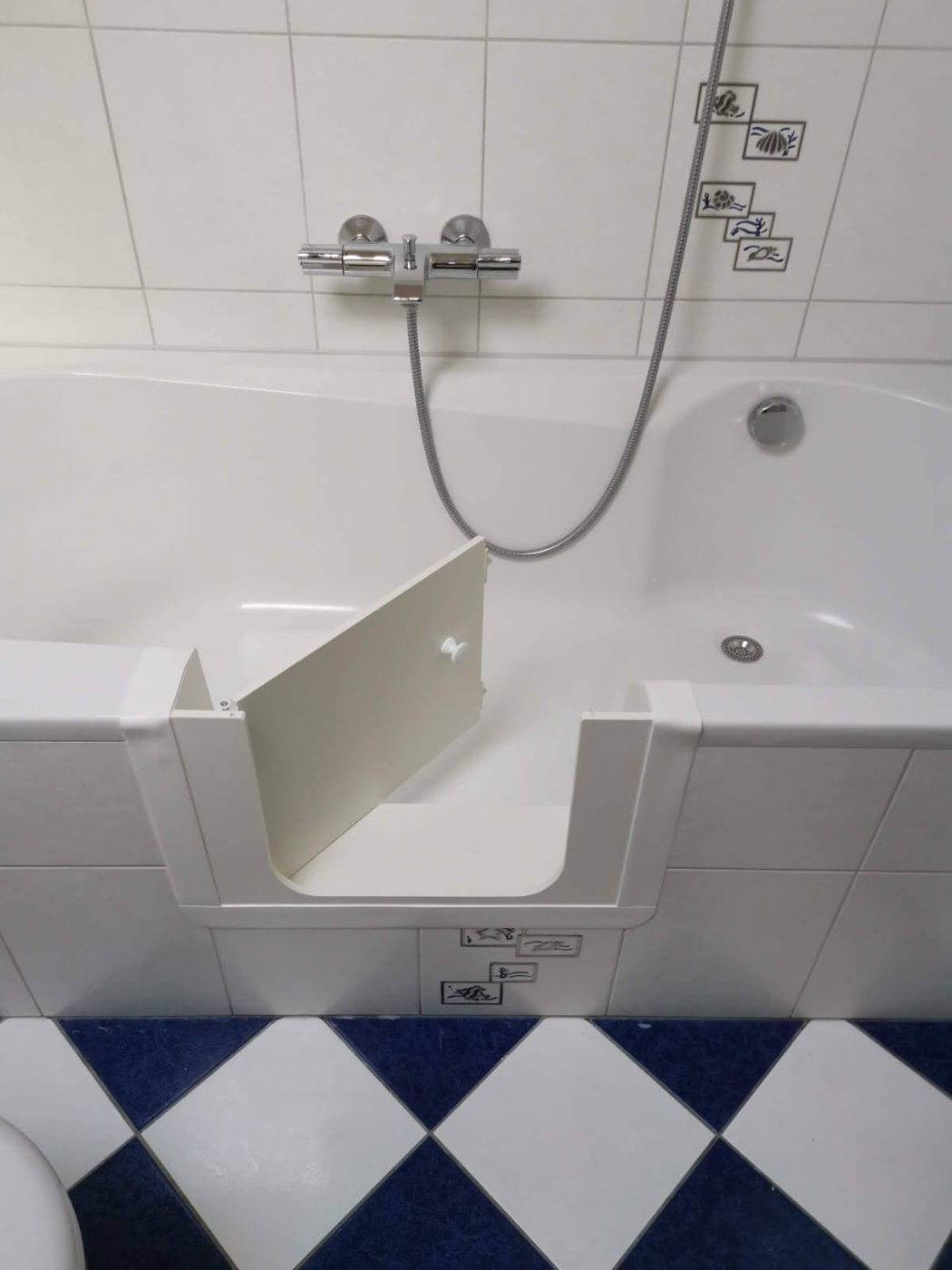 Recht ligbad met baddeur en zwart-witte vloer