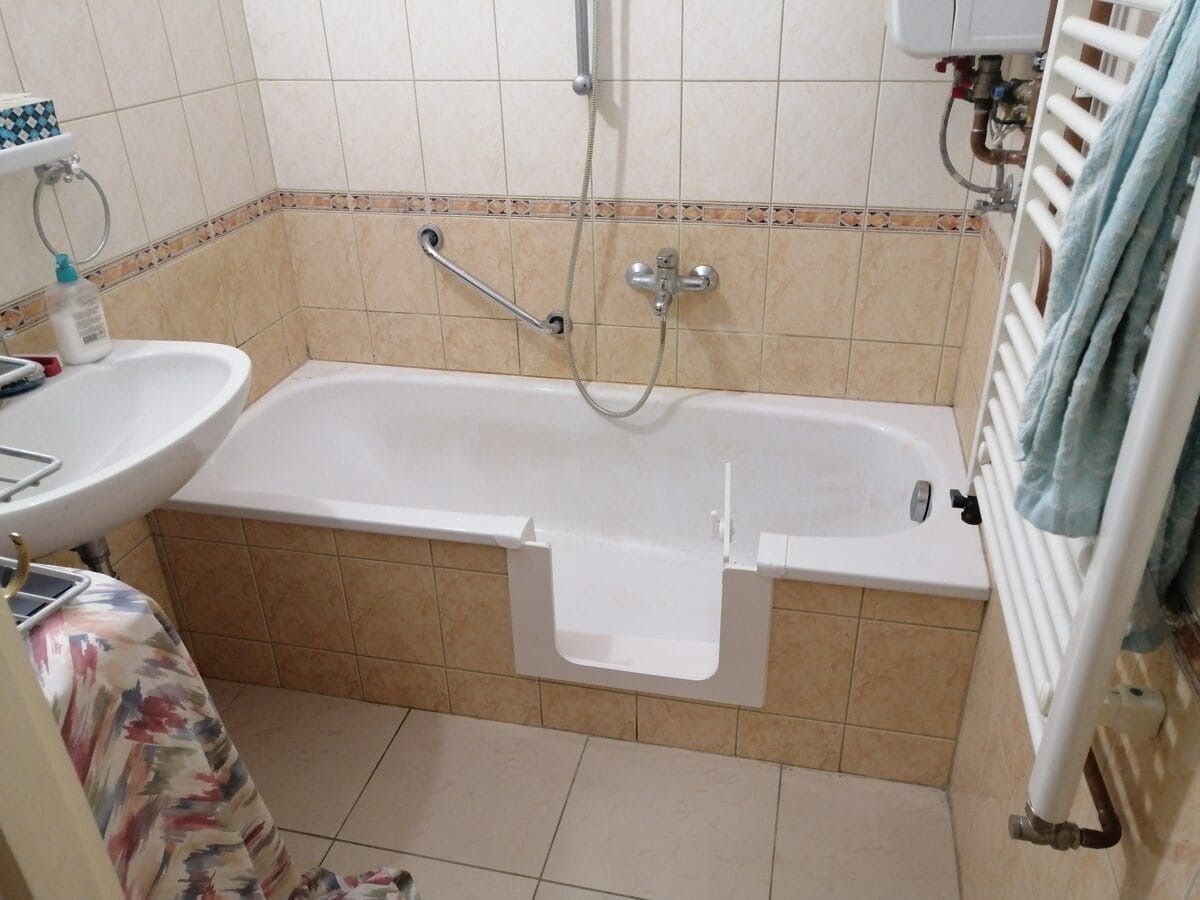 Kort ligbad met baddeur naast de radiator